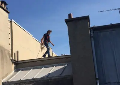 Yves Kervazo la parisienne de ramonage marchant sur un toit de Paris